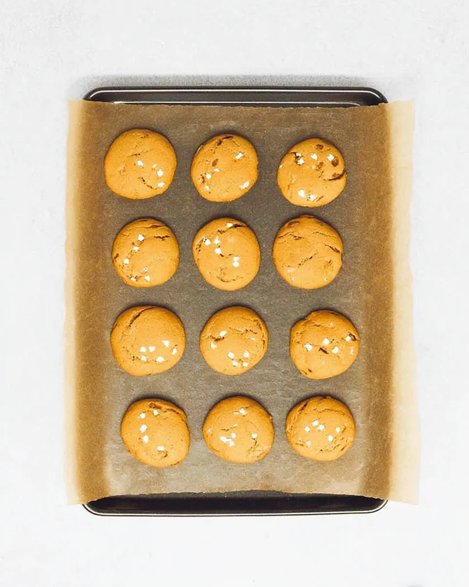 Baked cookies on parchment paper on a baking sheet.
