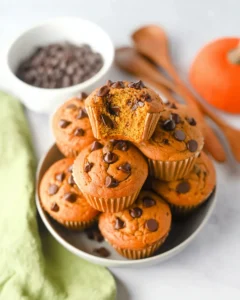 Homemade fall muffins with pumpkin puree and chocolate chips in a white bowl.