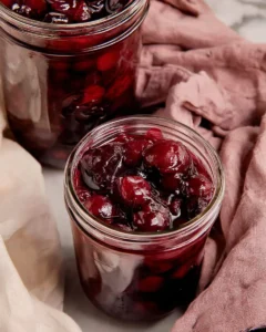 Juicy cherry pie filling in a small glass weck jar.
