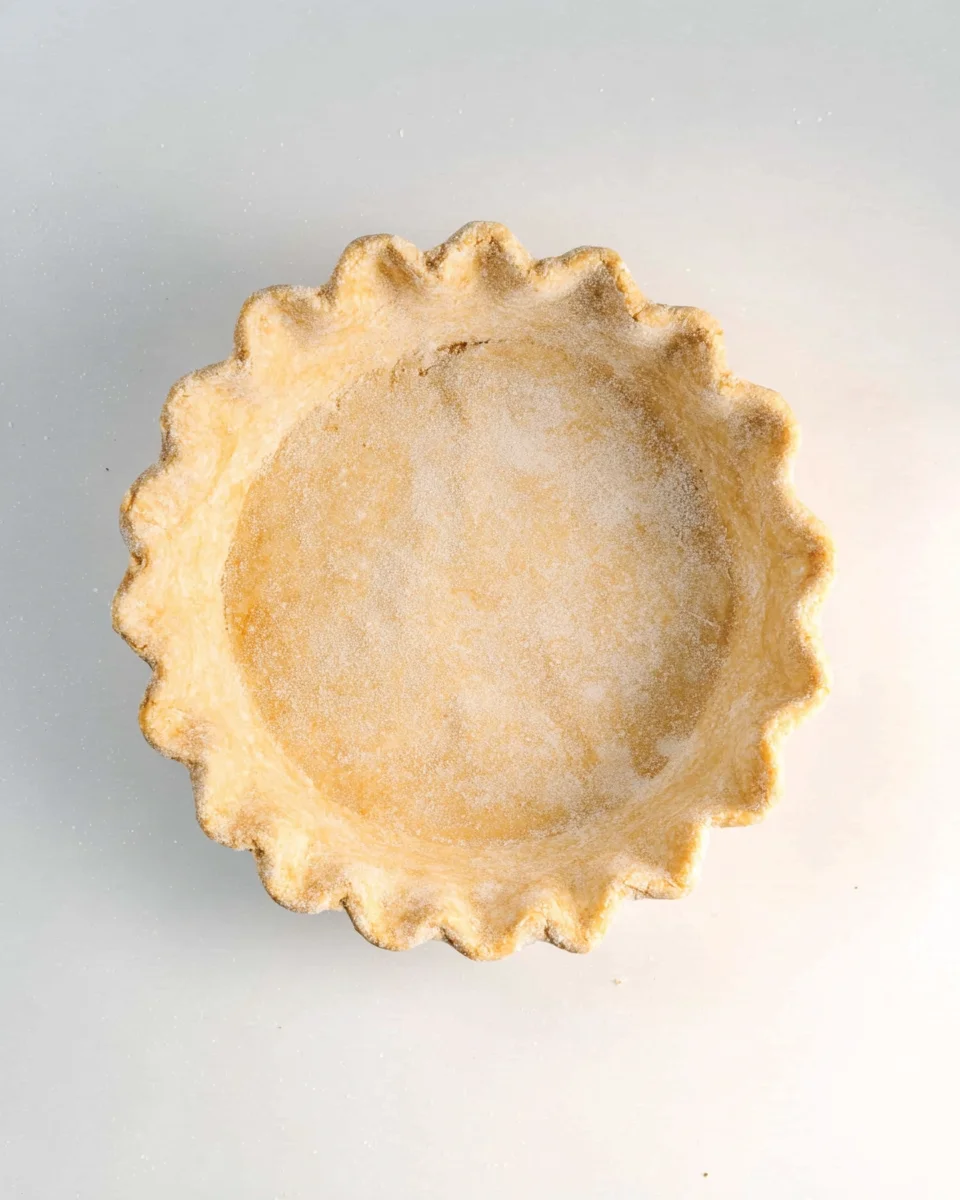 Graham flour pie dough crust in a pie plate with fluted edges.