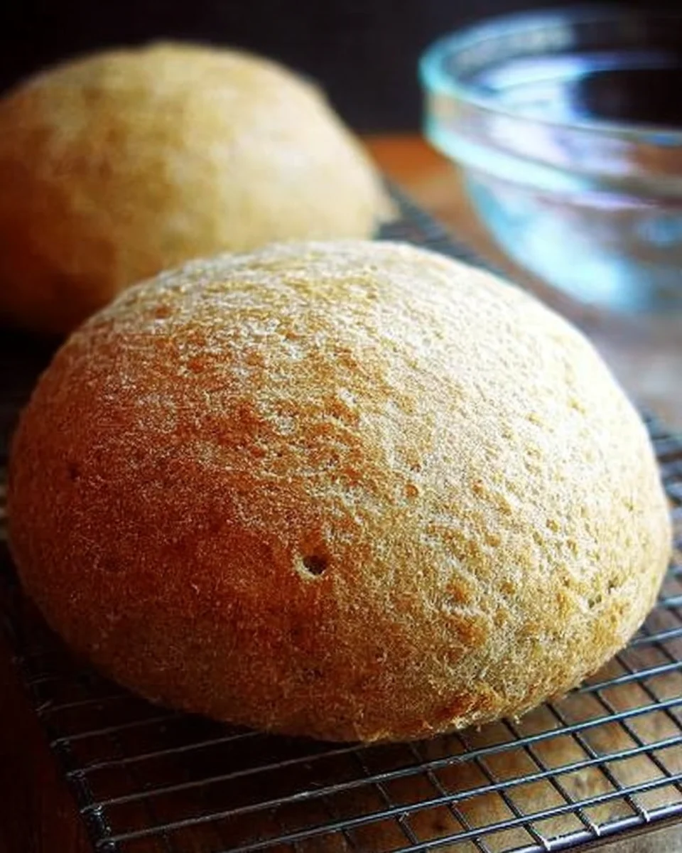 Freshly baked peasant bread turned onto cooling rack