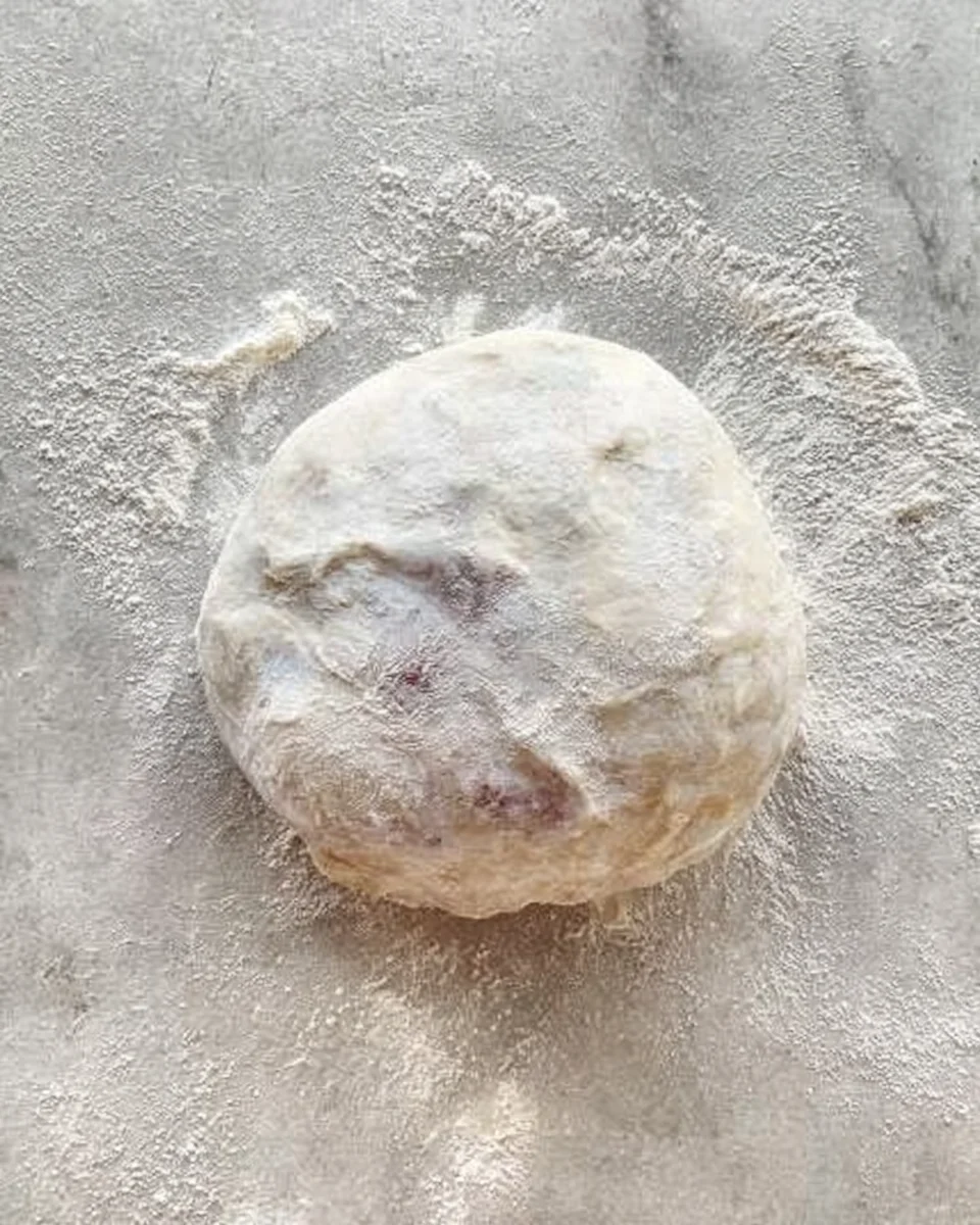 the dough rolled tightly, as if making a giant cinnamon roll, to form a large ball of dough.