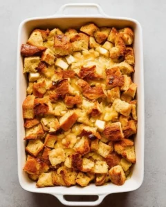baked overnight eggnog french toast casserole in white baking dish.