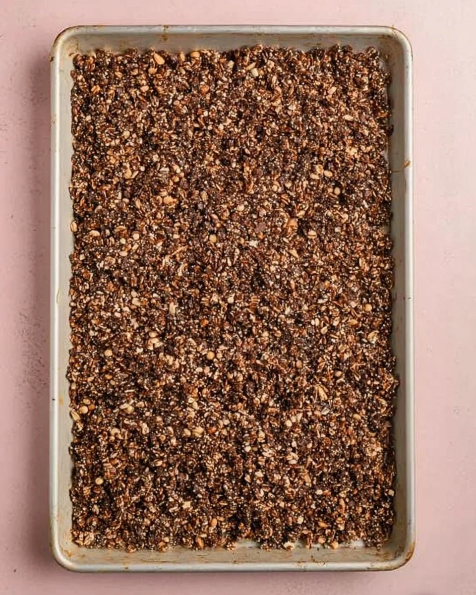 chocolate peanut butter granola on white sheet pan.