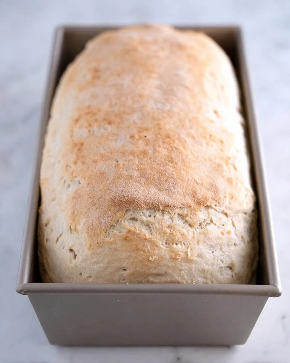 Baked loaf English muffin bread in bread pan.