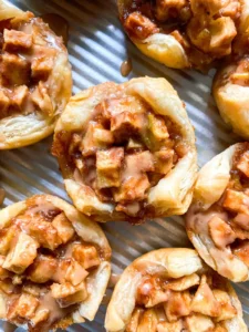 Mini apple pies on a sheet tray.