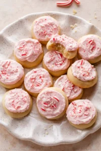 peppermint meltaway cookies with pink frosting and crushed candy canes on top.
