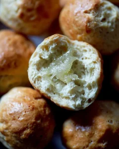 A halved and buttered thyme dinner roll.