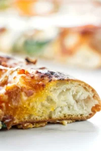 Close-up of pizza slice showing airy crust and melted cheese.