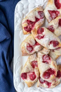 platter of raspberry danishes next to blue napkin