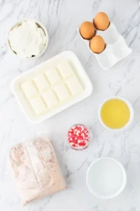 Photo of ingredients needed to make red velvet truffles including white chocolate, red velvet cake mix and sprinkles