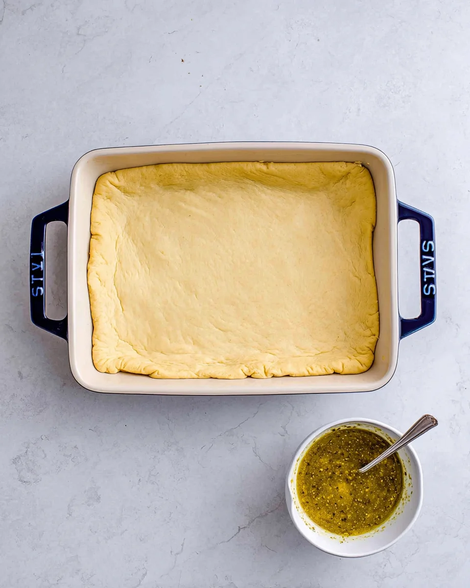 Crescent dough sheet covering filling with seems pinched together.