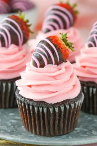 Close up of a chocolate covered strawberry cupcake on a silver tray.