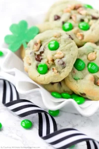 A close up of pistachio and chocolate chip cookies with green M&M's