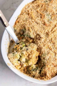 Broccoli casserole in baking dish with serving spoon.