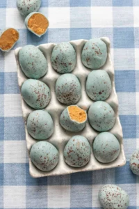 Soft blue speckled eggs on white ceramic tray, Easter eggs decorated for spring celebration.