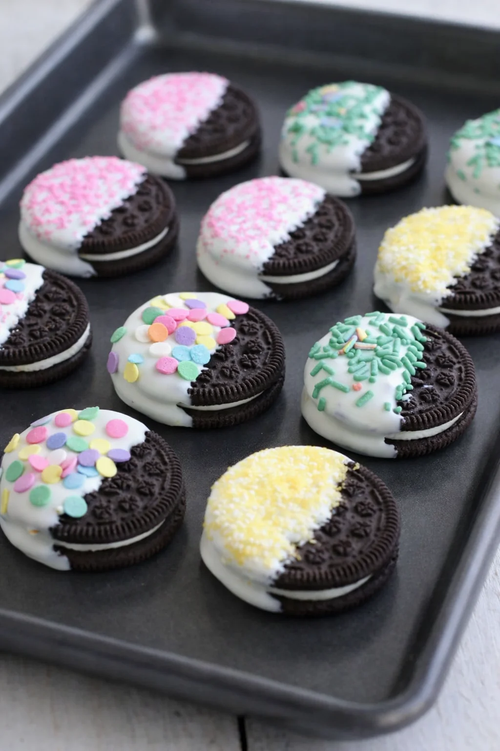 Tray of decorated Oreos resting on parchment, coating fully set and firm.