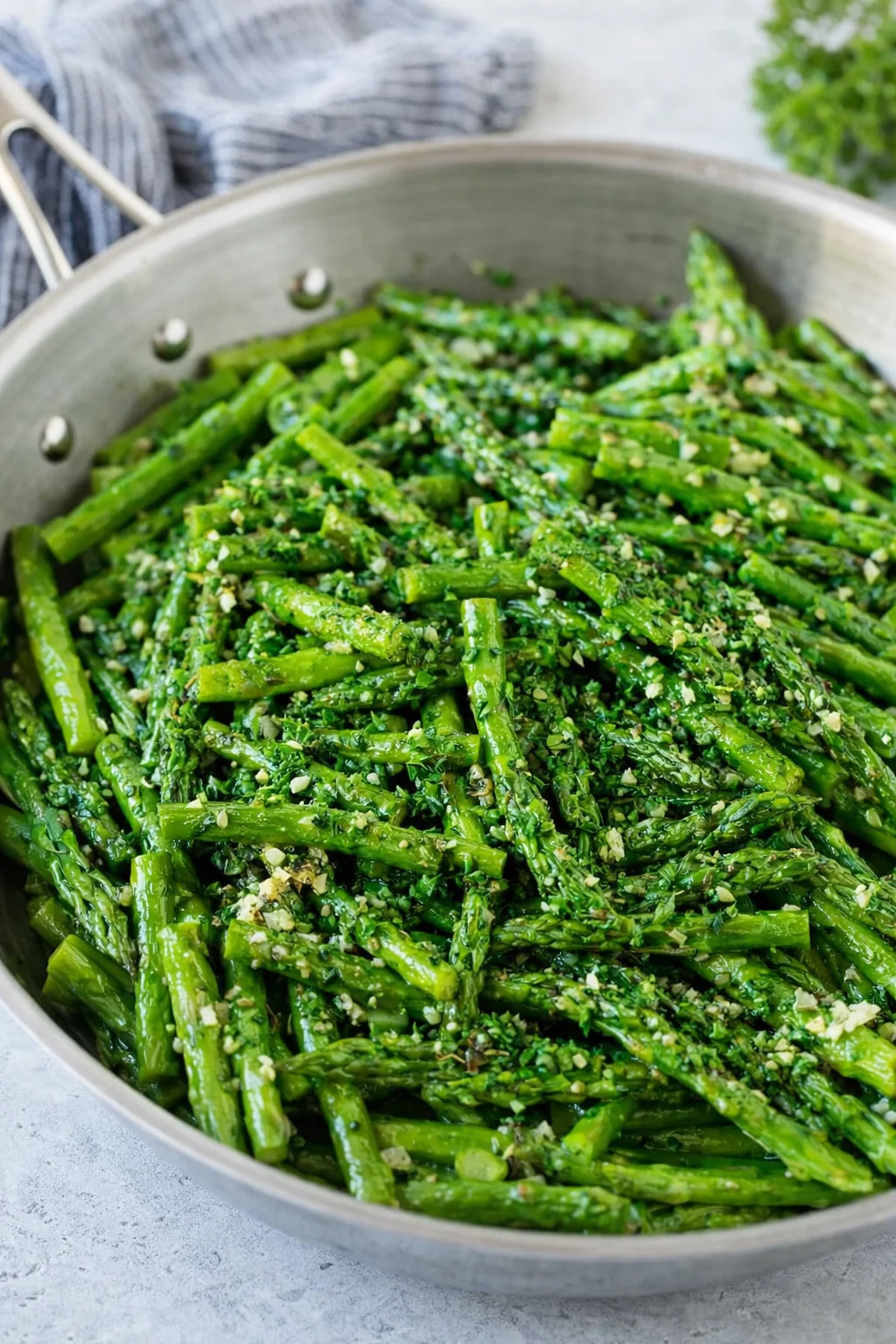 Asparagus plated and sprinkled with chopped parsley, ready to serve.