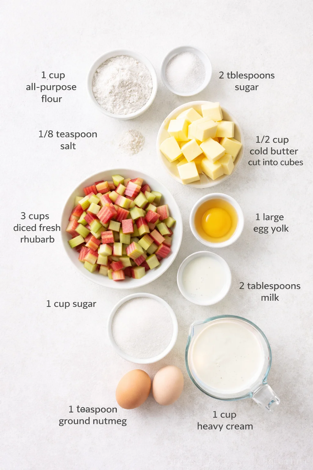 Measured ingredients arranged for Rhubarb Custard Kuchen: 1 cup all-purpose flour, 2 tablespoons sugar, 1/8 teaspoon salt, 1/2 cup cold butter, cut into cubes, 1 large egg yolk, 2 tablespoons milk