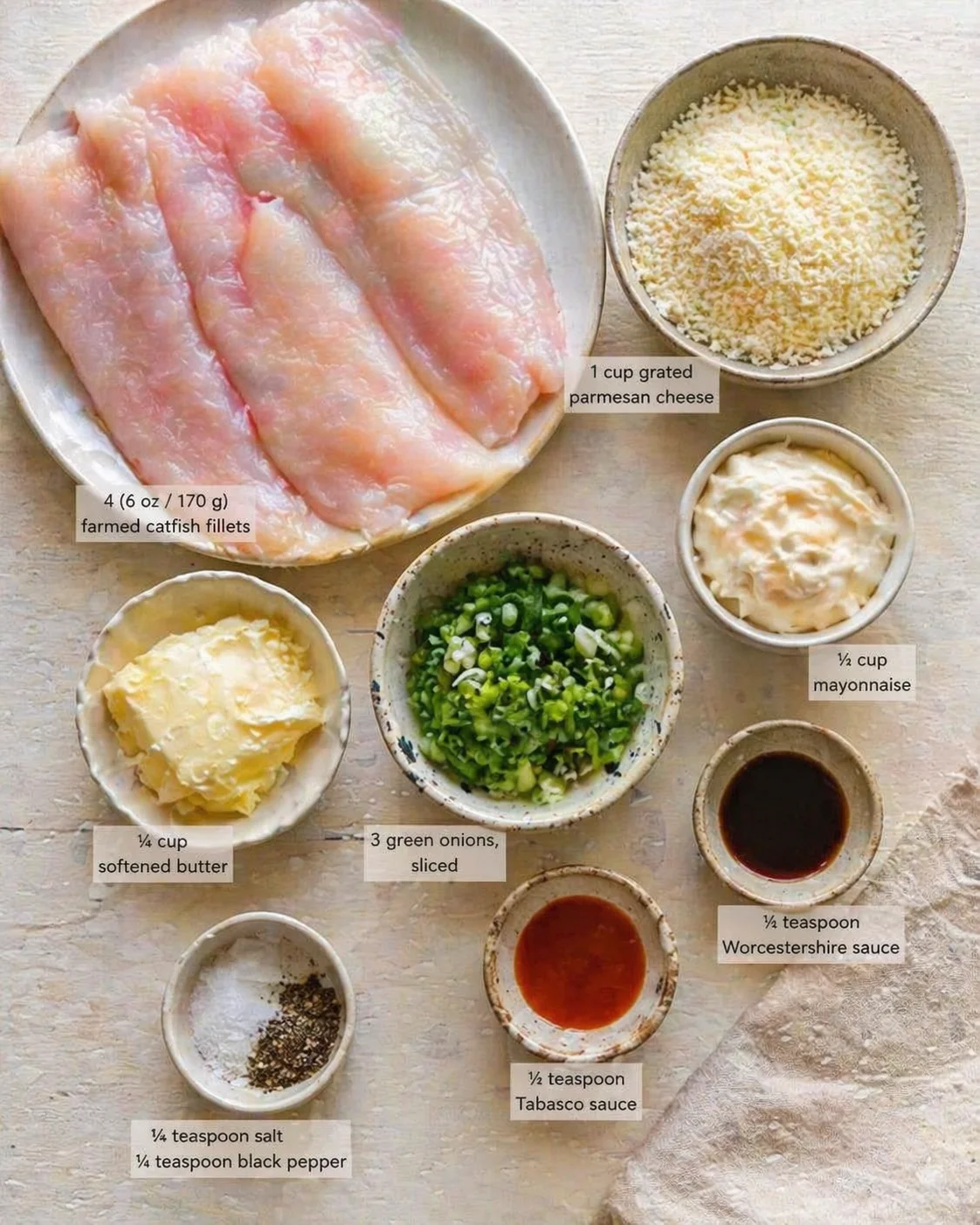 Measured ingredients arranged for Crispy Mississippi Catfish: A Foolproof Oven-Baked Recipe: 4 (6 oz / 170 g) farmed catfish fillets (U.S.), 1 cup grated parmesan cheese, ½ cup mayonnaise, ¼ cup softened butter, 3 green 