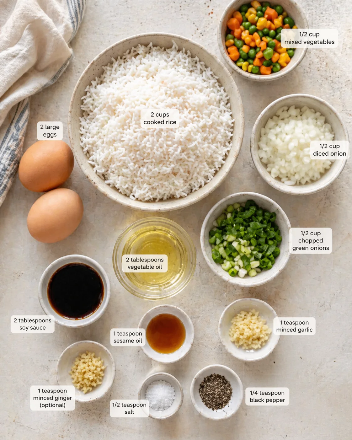 Measured ingredients arranged for Quick and Easy Egg Fried Rice - MushroomSalus: 2 cups cooked rice (day-old works best), 2 large eggs, 2 tablespoons vegetable oil, 1/2 cup diced onion, 1/2 cup chopped green onions, 1/2 