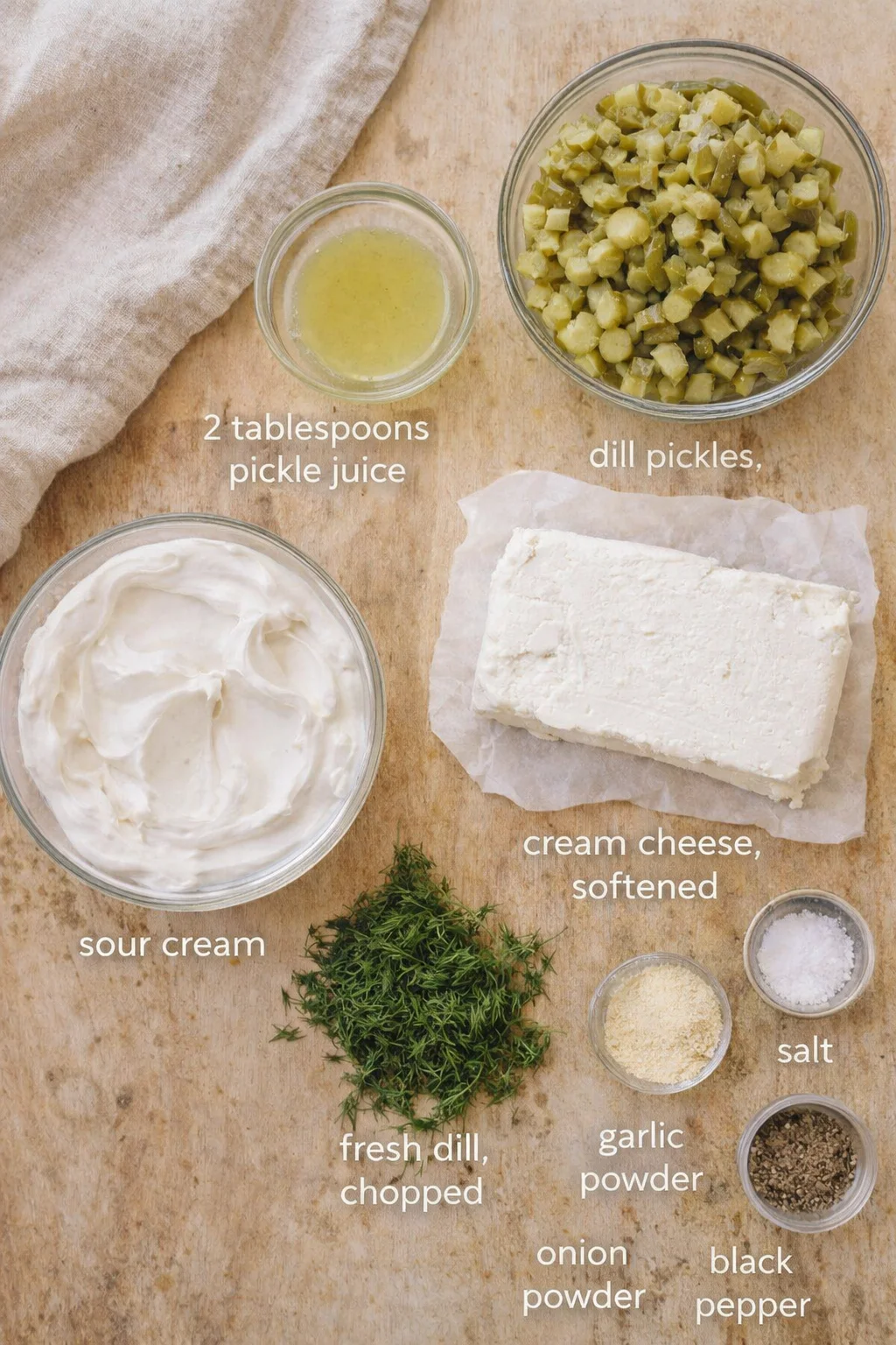 Measured ingredients arranged for Dill Pickle Dip Recipe: 8 oz cream cheese, softened, 1 cup sour cream, 1 cup dill pickles, finely chopped, 2 tablespoons pickle juice, 2 tablespoons fresh dill, chopped, 1 teaspoon garli