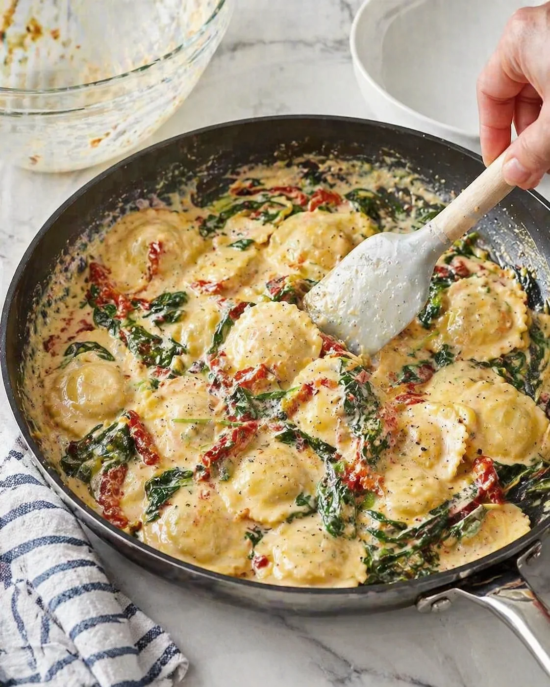 Cooked ravioli added to creamy Tuscan sauce and gently tossed to coat each piece.