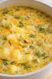 Creamy potato soup with carrots and dill in a light pot.