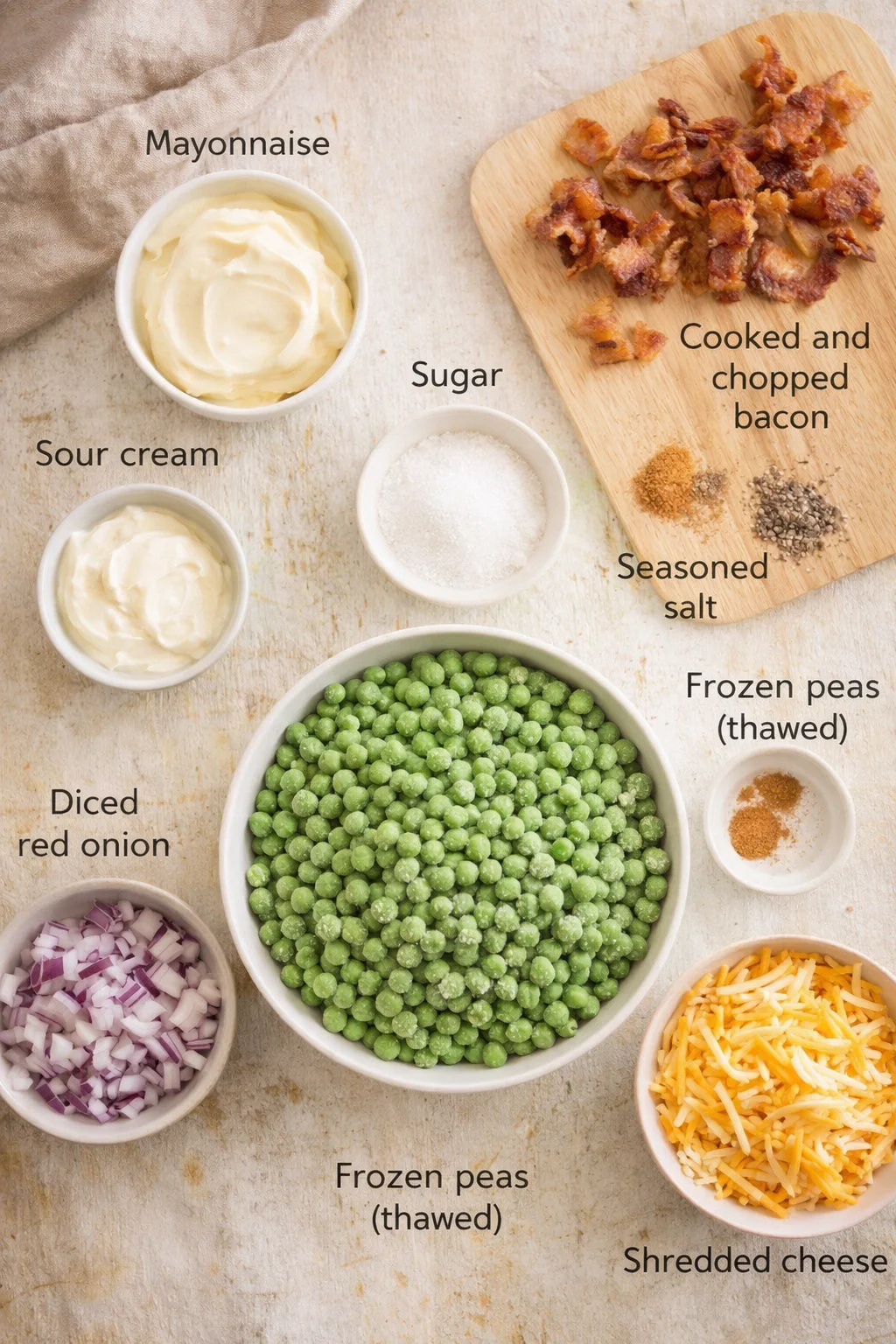 Overhead view of ingredients laid out for a recipe: peas, bacon, onions, dairy, cheese, and condiments with labels