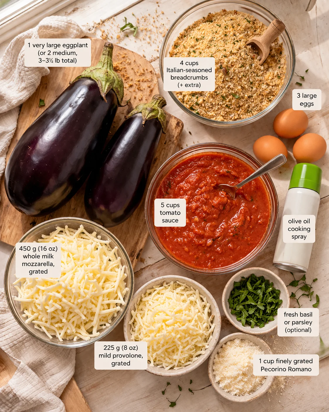Top-down view of eggplants, tomato sauce, breadcrumbs, cheeses, eggs, and herbs arranged on a wooden surface.