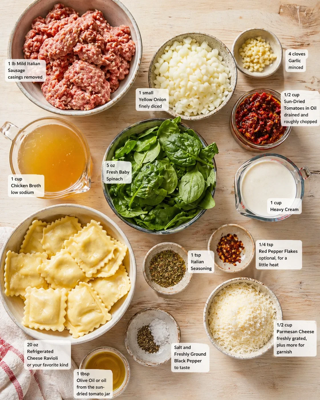 Overhead view of sausage ravioli ingredients: ground sausage, spinach, onions, garlic, sun-dried tomatoes, ravioli, cream, and cheese.