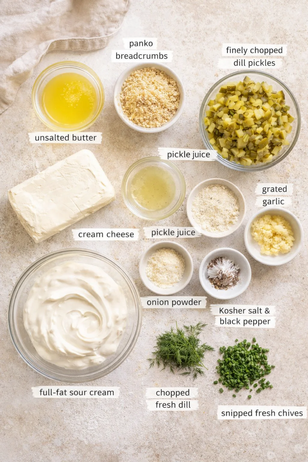 Flat lay of labeled ingredients for a creamy dip, including cream cheese, sour cream, butter, pickles, dill, and herbs.