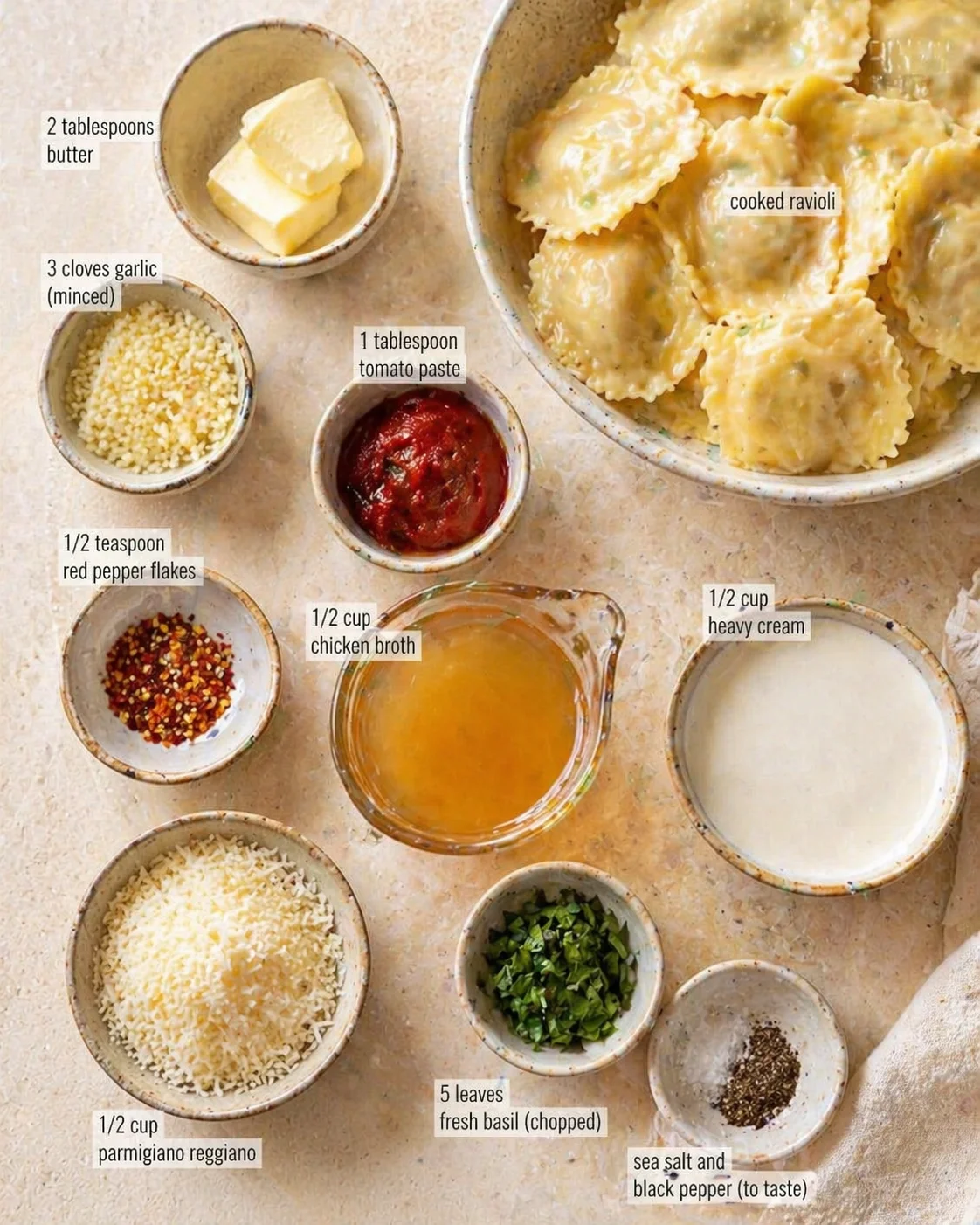 top-down view of ingredients like butter, garlic, tomato paste, parmesan, basil, and ravioli