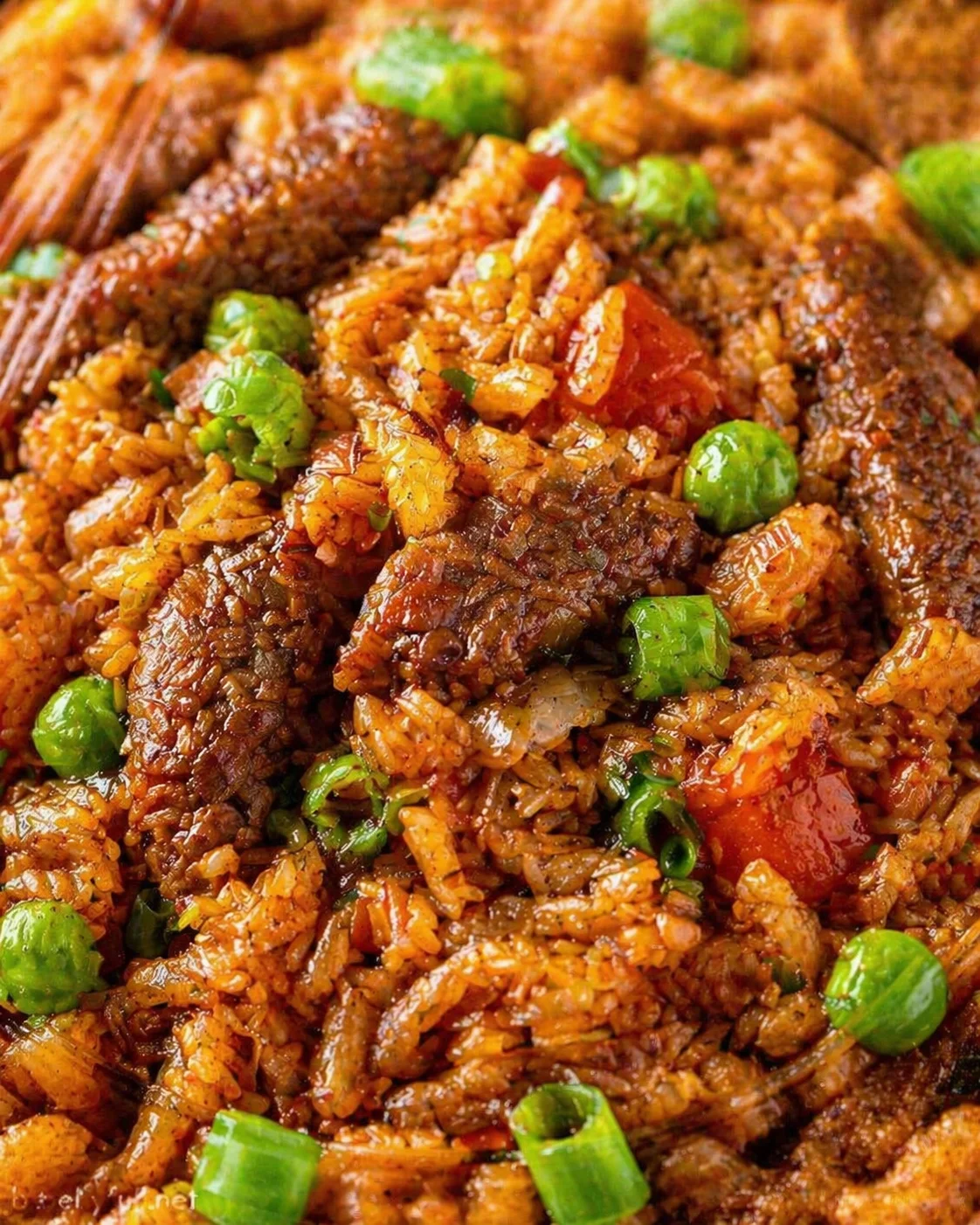 Close-up of glossy fried rice with peas and green onions.