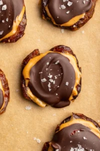 overhead image of smashed dates with peanut butter and chocolate on a baking sheet.