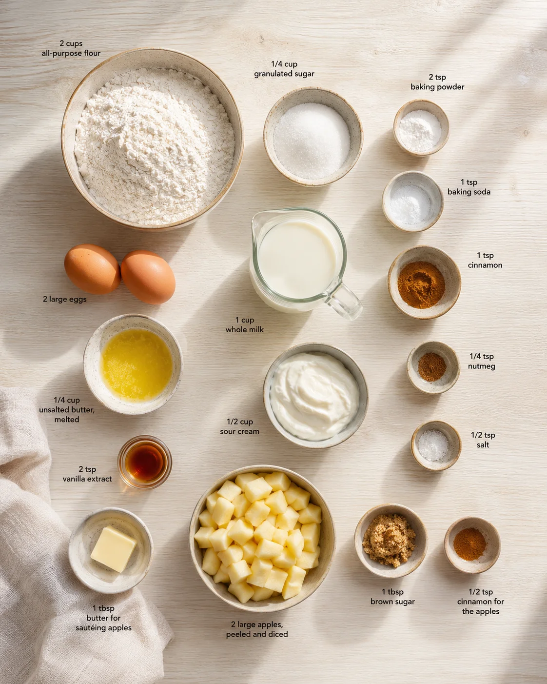 Overhead view of baking ingredients arranged on a wooden surface, ready for apple cake