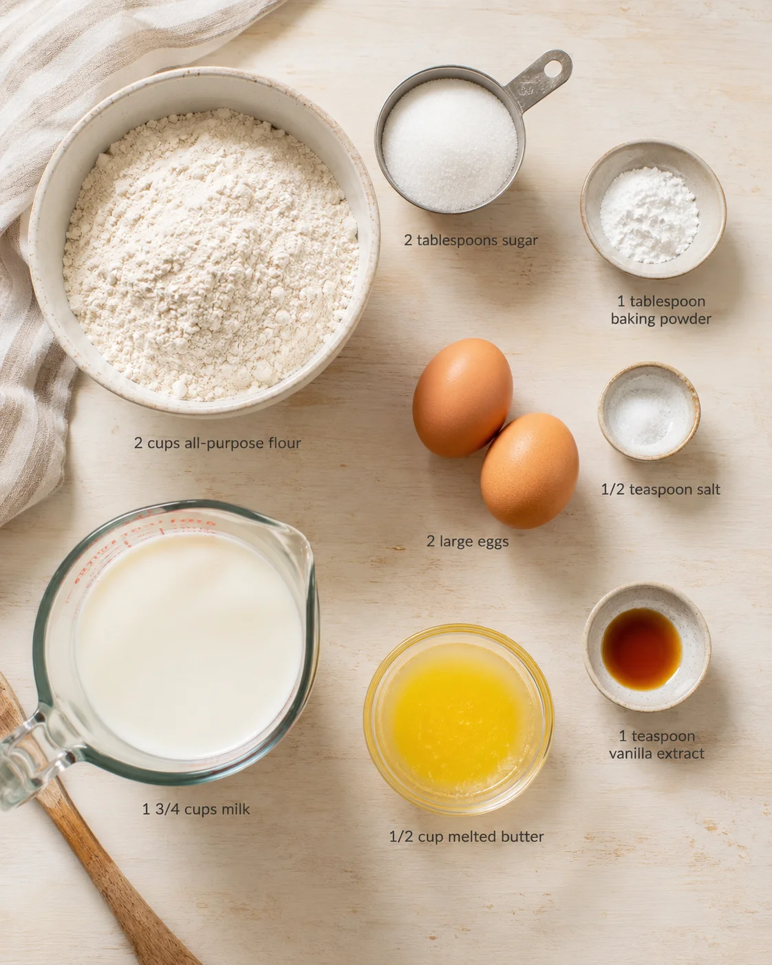 top-down view of baking ingredients laid out with labeled measurements on a light wooden surface