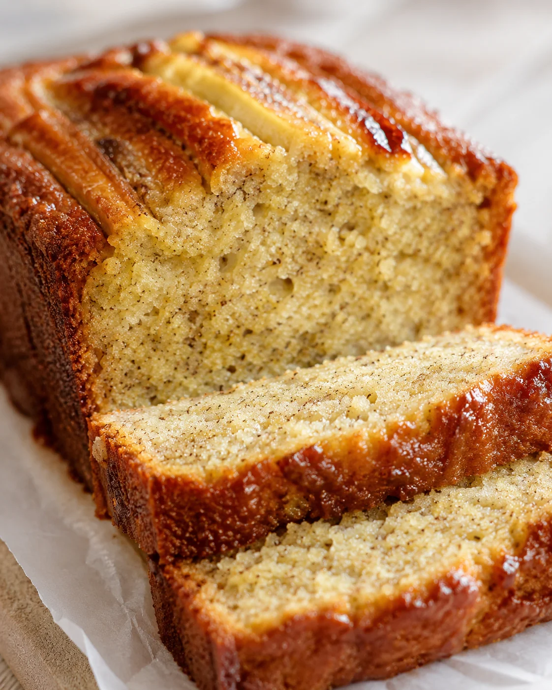 golden-brown banana bread loaf, sliced to reveal moist speckled crumb