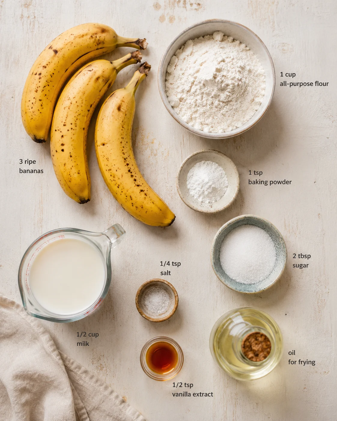 ripe bananas with flour, sugar, milk, and spices arranged on a light wooden surface.