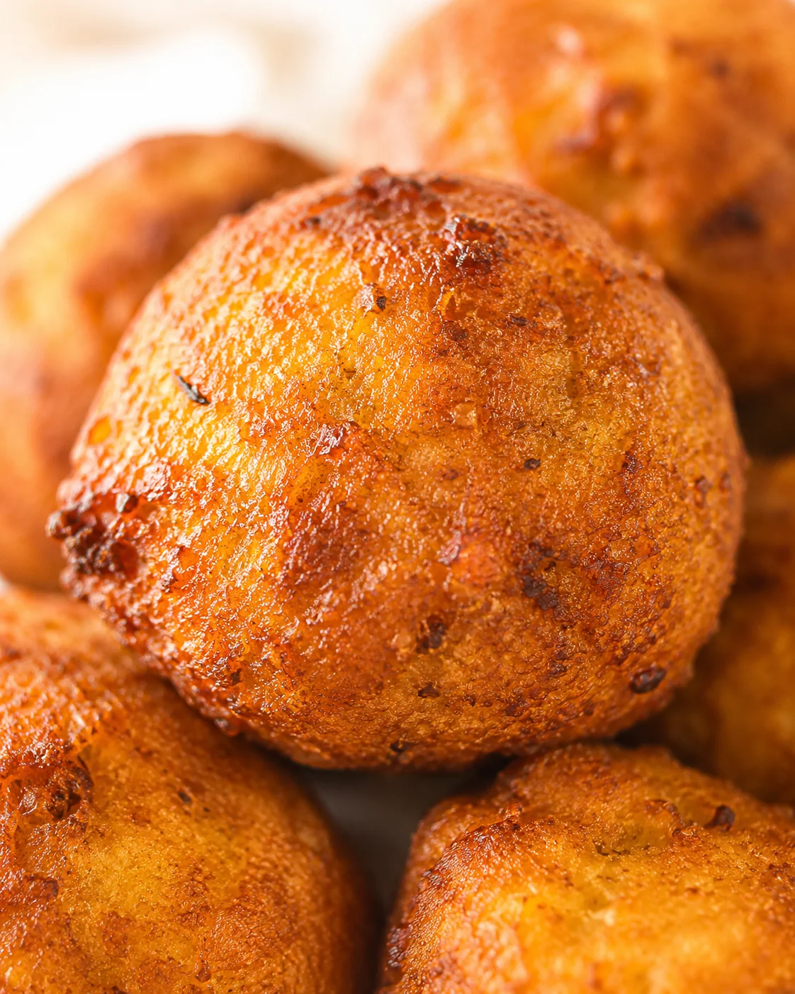 Close-up of golden-brown fried dough balls with a crispy blistered crust