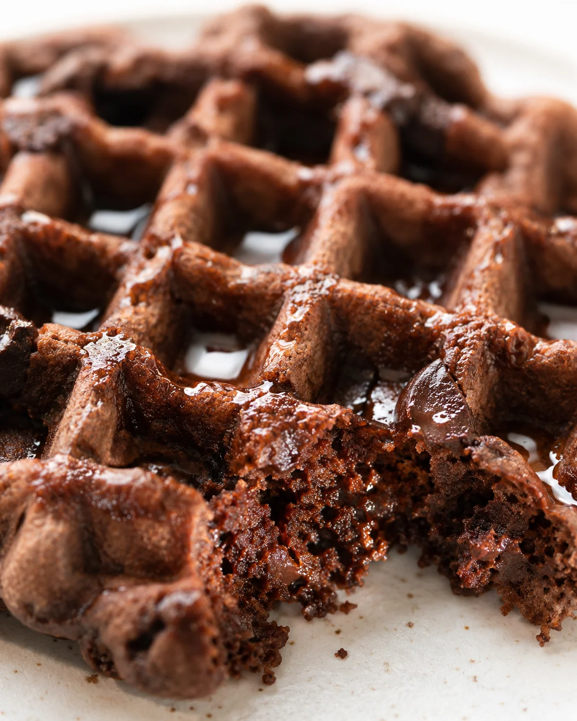 macro close-up of rich chocolate waffles with glossy syrup on a plate