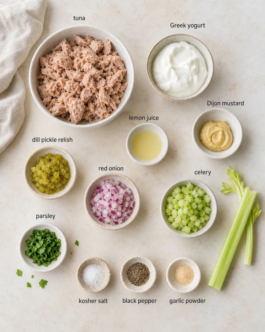 Top-down layout of tuna and condiments, including Greek yogurt, lemon juice, vegetables, and spices.